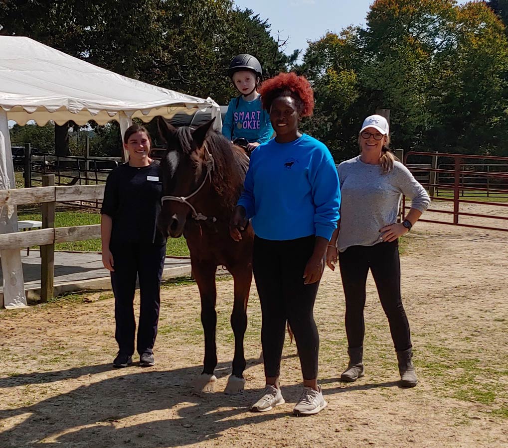 Another therapy rider with instructor, therapist and therapist assistant